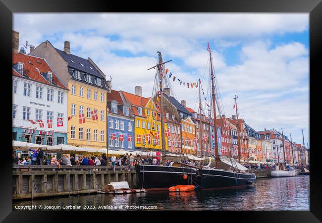 Copenhagen, Denmark - August 8, 2023: The most famous canal in Copenhagen with its quaint colorful houses overlooking the docked sailboats. Framed Print by Joaquin Corbalan