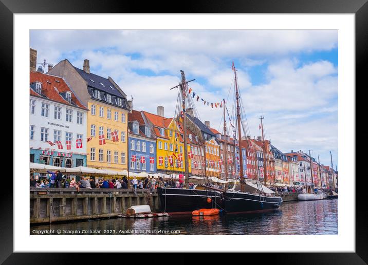 Copenhagen, Denmark - August 8, 2023: The most famous canal in Copenhagen with its quaint colorful houses overlooking the docked sailboats. Framed Mounted Print by Joaquin Corbalan