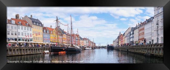 Copenhagen, Denmark - August 8, 2023: The most famous canal in Copenhagen with its quaint colorful houses overlooking the docked sailboats. Framed Print by Joaquin Corbalan