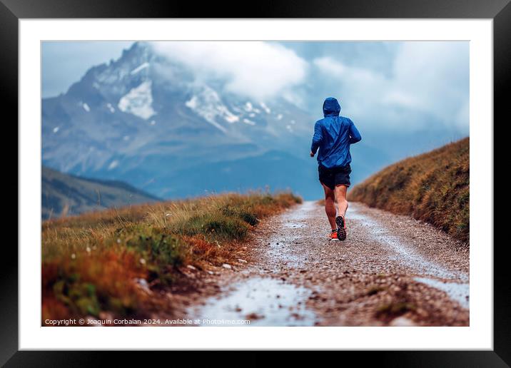 A mountain runner enjoys the trails, a day of rain Framed Mounted Print by Joaquin Corbalan