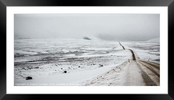 Road covered in snow one winter stormy day, very dangerous to drive due to adverse weather. Framed Mounted Print by Joaquin Corbalan