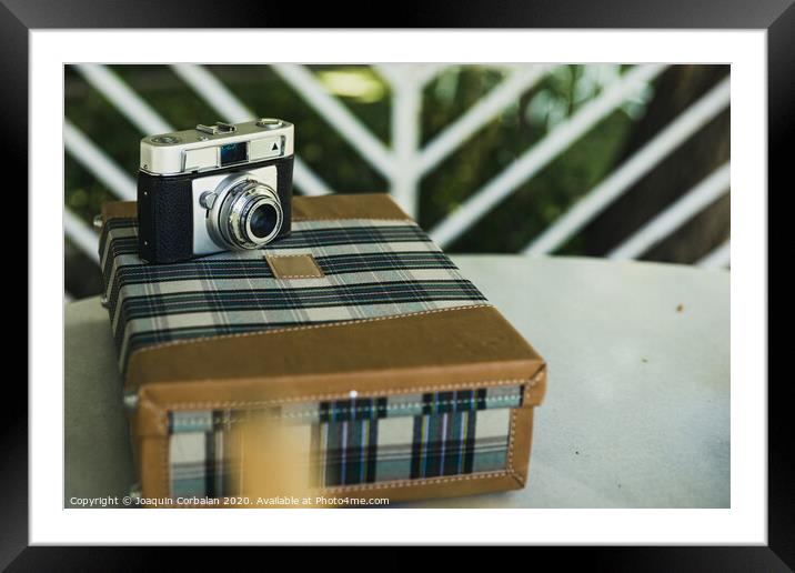 Old analog photo camera on a vintage travel suitcase. Framed Mounted Print by Joaquin Corbalan