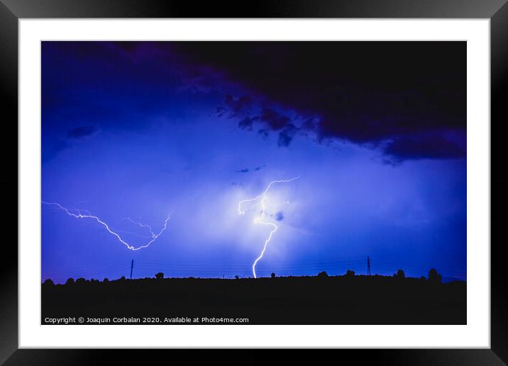 Rays in a night storm with light and clouds. Framed Mounted Print by Joaquin Corbalan