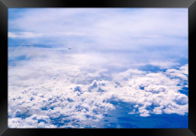 Plane of commercial flights crossing a sky of blue and white clouds seen from above, on the Mediterranean. Framed Print by Joaquin Corbalan