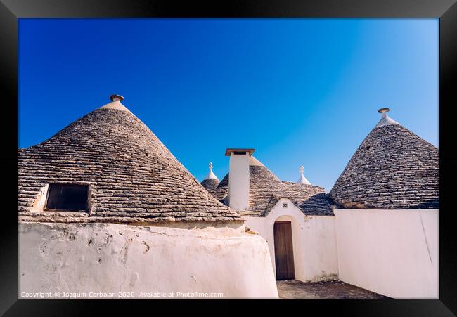 Stone tiles cover the roofs of the trulli in Alberobello, an Italian city to visit on a trip to Italy. Framed Print by Joaquin Corbalan