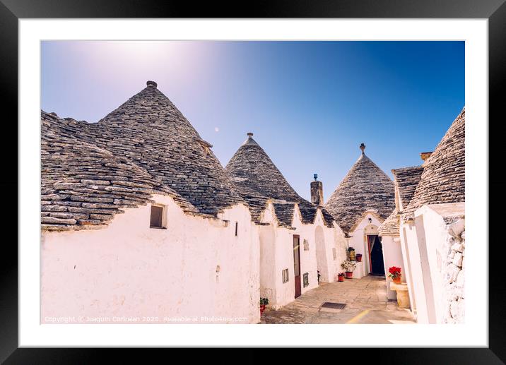 Houses of the tourist and famous Italian city of Alberobello, with its typical white walls and trulli conical roofs. Framed Mounted Print by Joaquin Corbalan