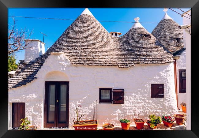 Houses of the tourist and famous Italian city of Alberobello, with its typical white walls and trulli conical roofs. Framed Print by Joaquin Corbalan