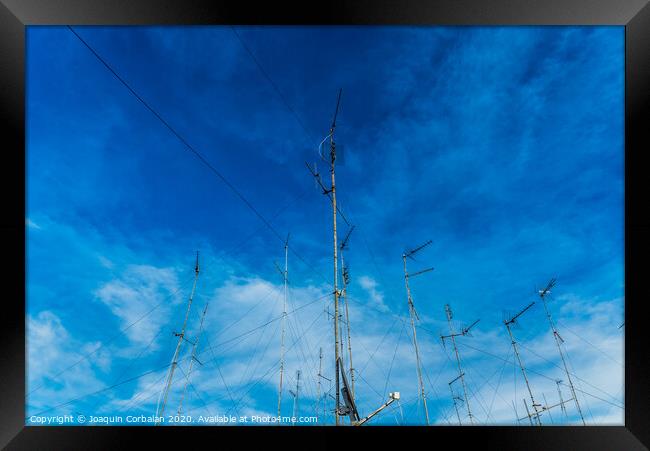 Television antennas on the roof of an old building with dramatic sky. Framed Print by Joaquin Corbalan