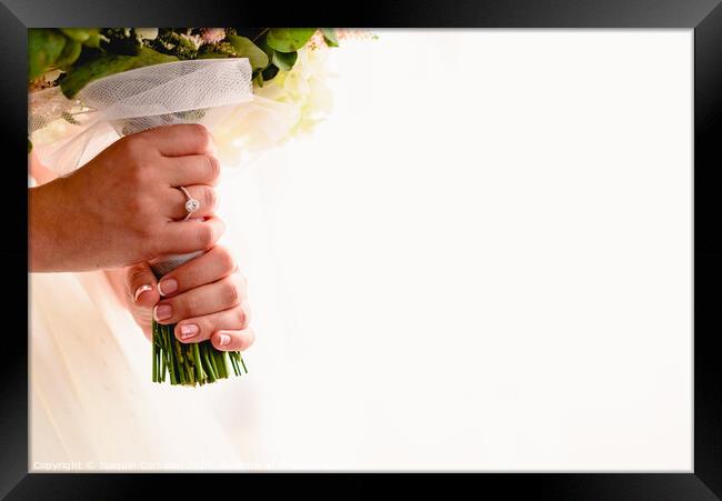 A woman's hand with wedding ring while holding her bouquet, plenty of white copy space. Framed Print by Joaquin Corbalan