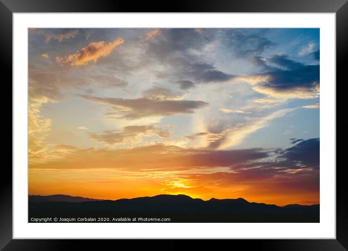 Beautiful sunset with the sun of orange tones behind the mountains and deep blue sky Framed Mounted Print by Joaquin Corbalan
