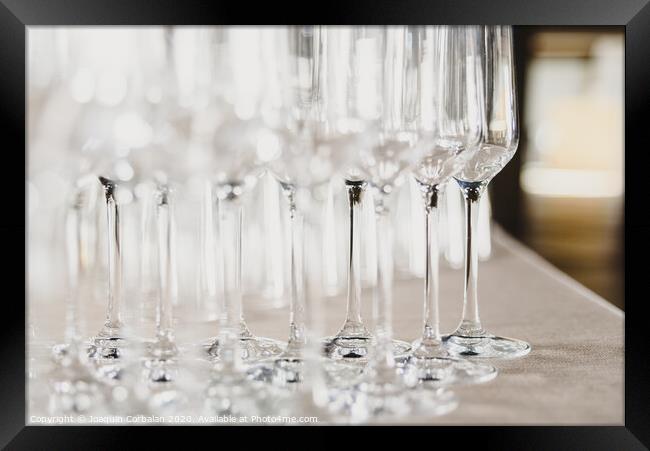 Group of empty and transparent champagne glasses in a restaurant.Group of empty and transparent champagne glasses in a restaurant. Framed Print by Joaquin Corbalan