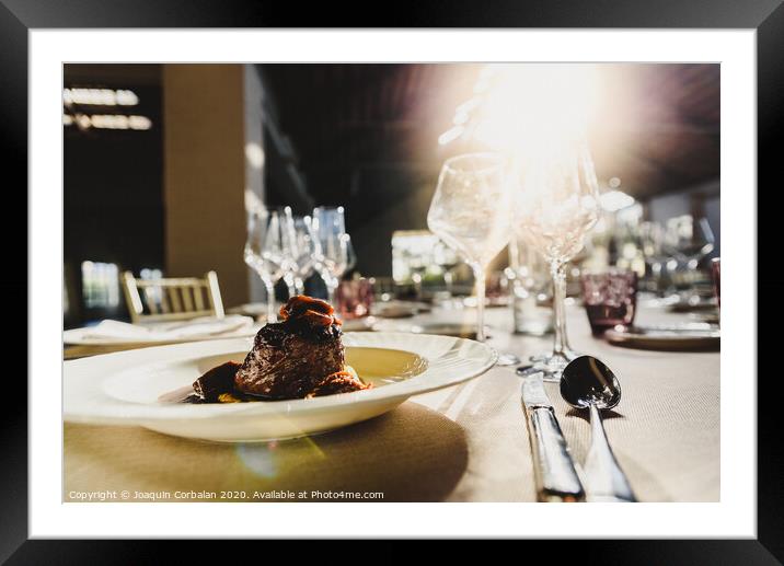 Exquisite veal dish with sauce served in luxury cutlery with sunbeams in a restaurant. Framed Mounted Print by Joaquin Corbalan