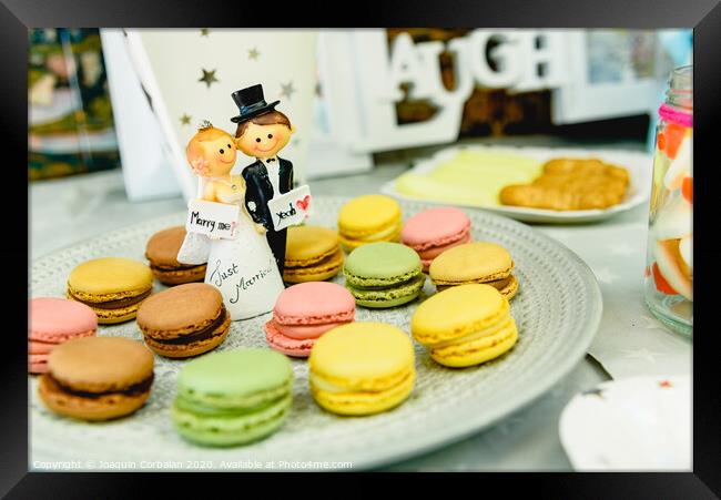 Happy newlywed dolls on a plate with macarons in the candy bar of a wedding. Framed Print by Joaquin Corbalan