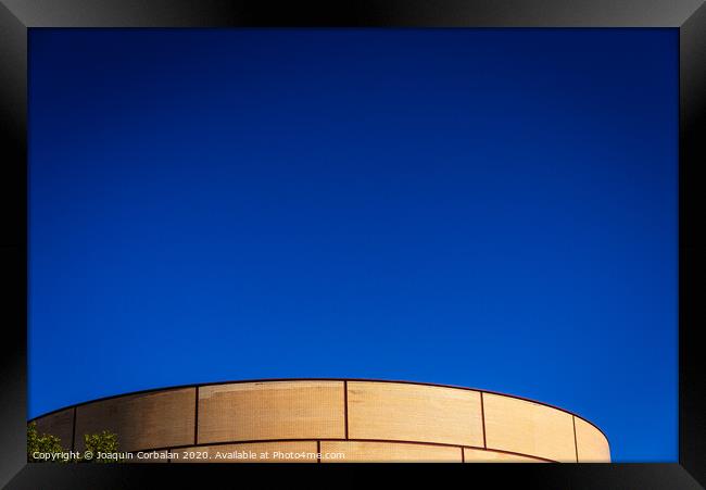 Background of intense blue sky in an industrial area with a brick construction with round shapes. Framed Print by Joaquin Corbalan
