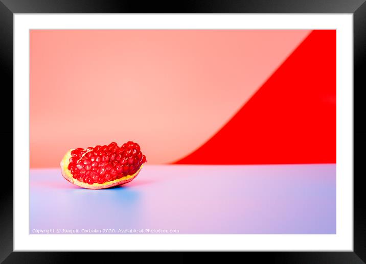 Autumn is the time of pomegranates, open fruit isolated on plain colored backgrounds. Framed Mounted Print by Joaquin Corbalan