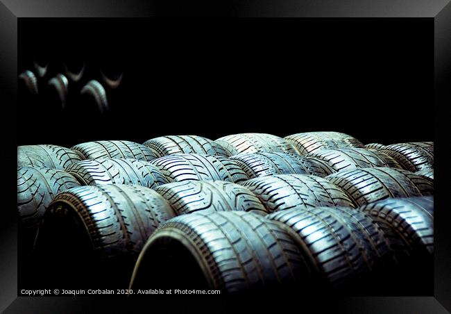 Old tires and racing wheels stacked in the sun Framed Print by Joaquin Corbalan