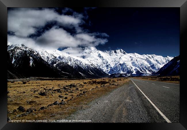 Snowy mountains among clouds from road Framed Print by Joaquin Corbalan