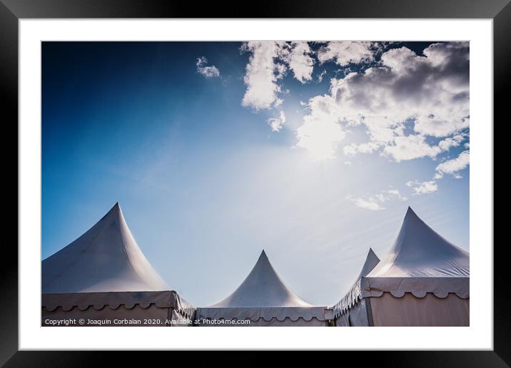 Peaks of three pyramidal white tents and blue sky background with space for advertisers text. Framed Mounted Print by Joaquin Corbalan
