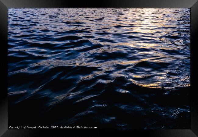 Waves on the surface of the sea water at dusk with compact, solid and deeply calm texture. Framed Print by Joaquin Corbalan