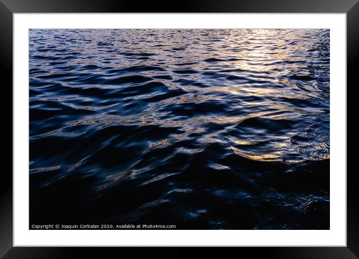 Waves on the surface of the sea water at dusk with compact, solid and deeply calm texture. Framed Mounted Print by Joaquin Corbalan