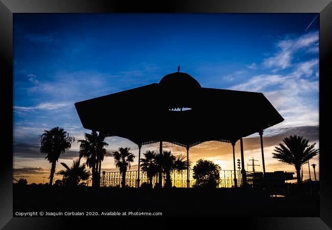 Silhouette of a pergola at sunset on a cloudy afternoon in the port of the Marina Real of Valencia, Spain. Framed Print by Joaquin Corbalan