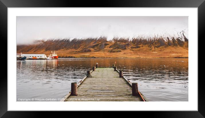 Small wooden pier centered on a lake, facing a snowy mountain. Framed Mounted Print by Joaquin Corbalan