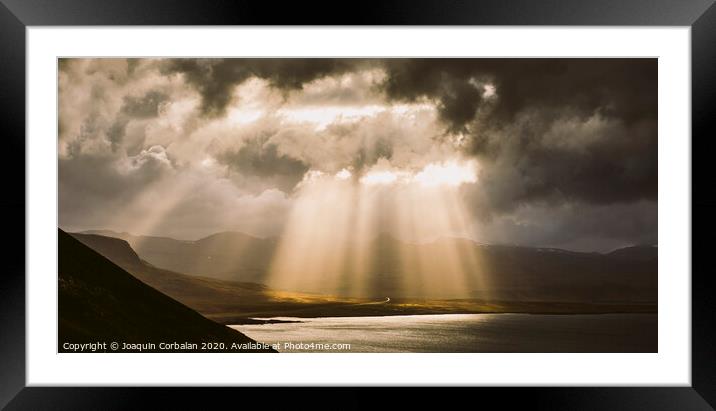 Sunbeams fall among the clouds in a lake between mountains. Framed Mounted Print by Joaquin Corbalan