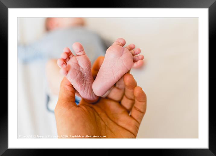 Newborn feet skinning held by mommy Framed Mounted Print by Joaquin Corbalan