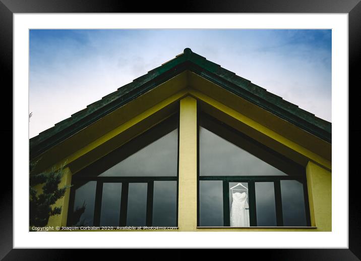 Wedding dress hanging from a window seen from outside with intense blue sky. Framed Mounted Print by Joaquin Corbalan