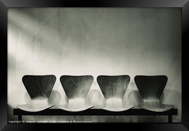 Waiting room with empty wooden chairs, concept of waiting and passage of time, black and white image, free space for text. Framed Print by Joaquin Corbalan
