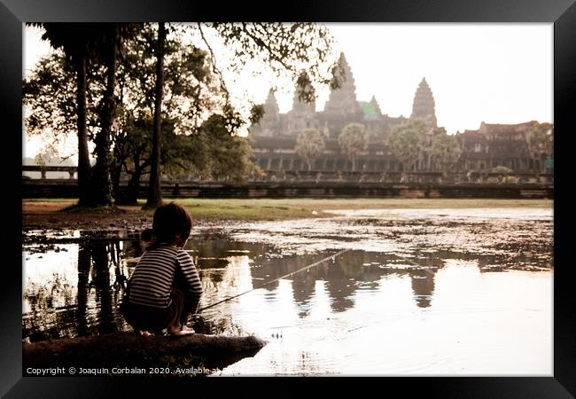 Girl fishing in the lake of Angkor Wat, ancient Cambodian city hidden in the forest very visited by tourists Framed Print by Joaquin Corbalan