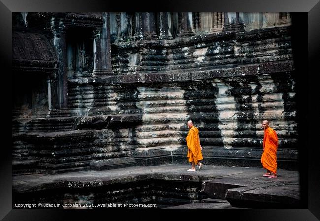 tibetan monks in orange robes visiting remote Cambodian temples to meditate. Framed Print by Joaquin Corbalan