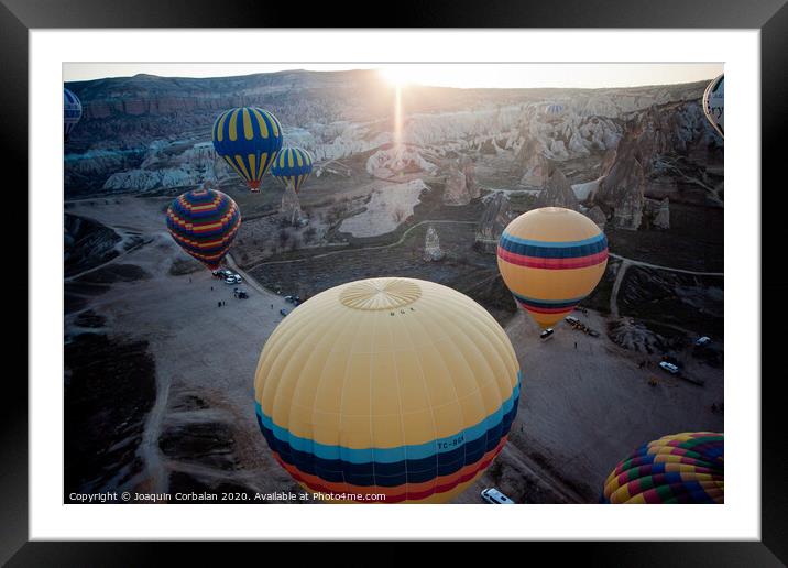 Hot air balloons for tourists flying over rock formations at sunrise in the valley of Cappadocia. Framed Mounted Print by Joaquin Corbalan