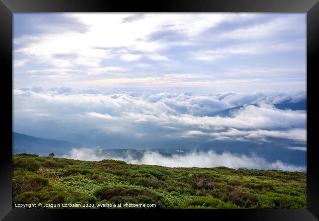 Scene of a winter cloudy sky from the top of a mountain peak. Framed Print by Joaquin Corbalan