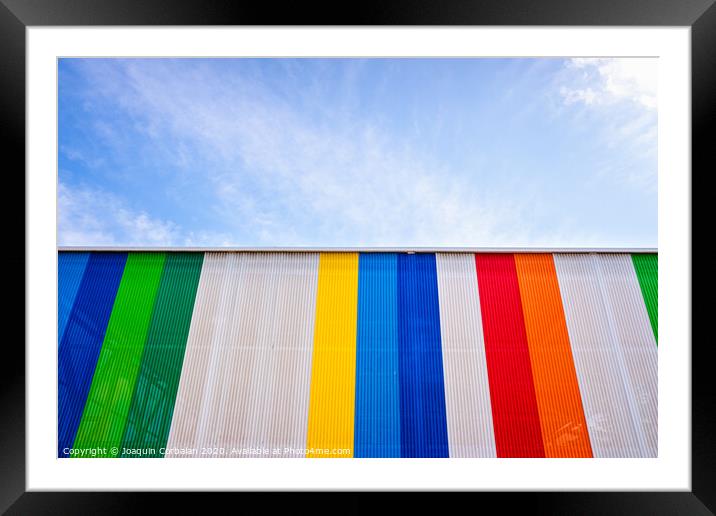 Facade with colored lines, against the blue sky in the background. Framed Mounted Print by Joaquin Corbalan