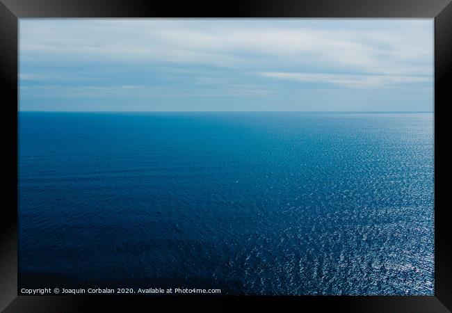 Calm blue sea without waves seen from a cliff with room for text Framed Print by Joaquin Corbalan