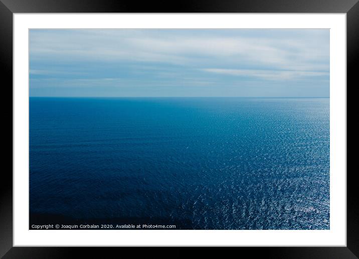 Calm blue sea without waves seen from a cliff with room for text Framed Mounted Print by Joaquin Corbalan