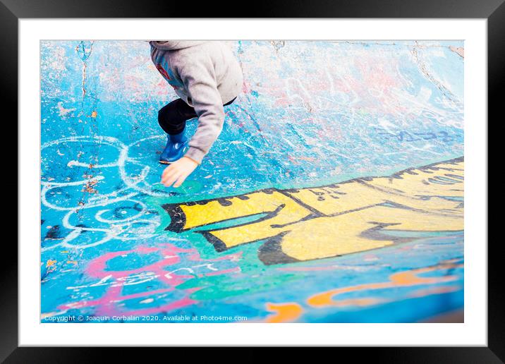 Boy running inside an urban skatepark with sweatshirt having fun, blue tones. Framed Mounted Print by Joaquin Corbalan