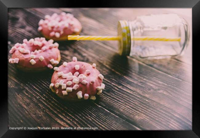Pair of buns frosted with pink sugar and unhealthy marshsmallows next to a glass jar. Framed Print by Joaquin Corbalan