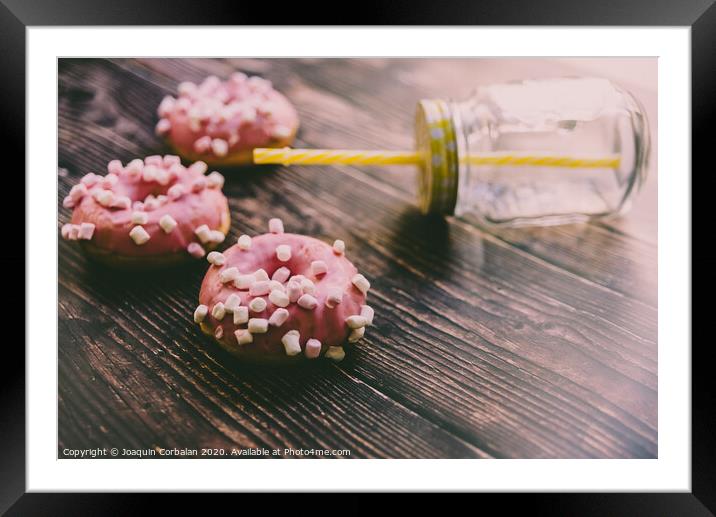 Pair of buns frosted with pink sugar and unhealthy marshsmallows next to a glass jar. Framed Mounted Print by Joaquin Corbalan