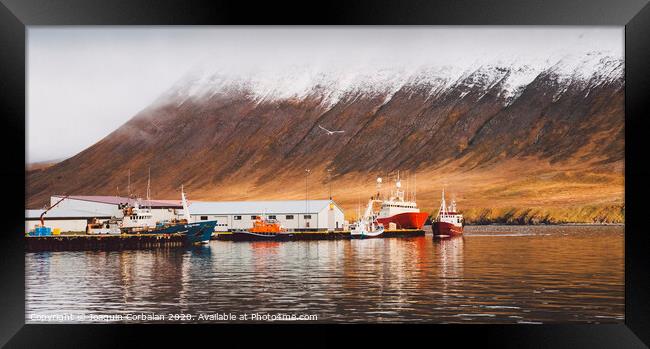 Fishing port of the village of Seydisfjordur, in Iceland, with vibrant colors and reflections in the sea of fishing boats. Framed Print by Joaquin Corbalan