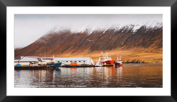 Fishing port of the village of Seydisfjordur, in Iceland, with vibrant colors and reflections in the sea of fishing boats. Framed Mounted Print by Joaquin Corbalan
