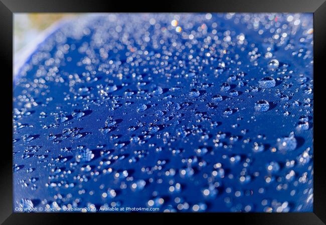 Detail of water drops on a plastic fabric colored in the sun. Framed Print by Joaquin Corbalan