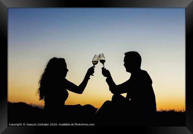 Enamored couple embraced at sunset in a backlit photo Framed Print by Joaquin Corbalan