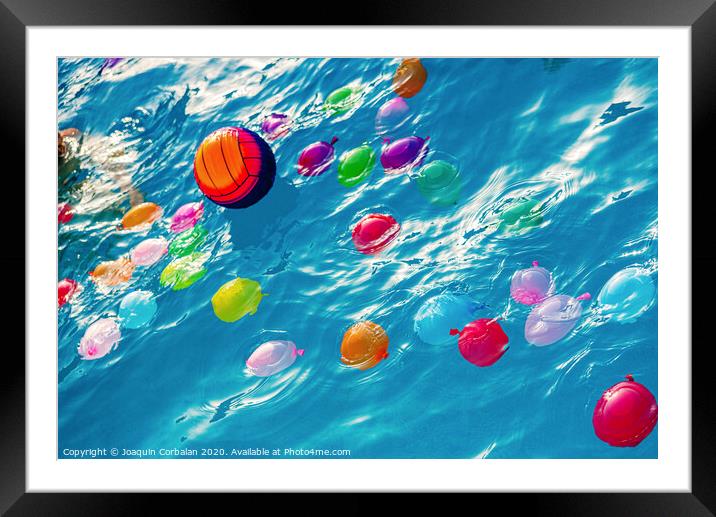 Group of many colorful plastic water balloons floating in the water of a pool to entertain their children on summer vacations. Framed Mounted Print by Joaquin Corbalan