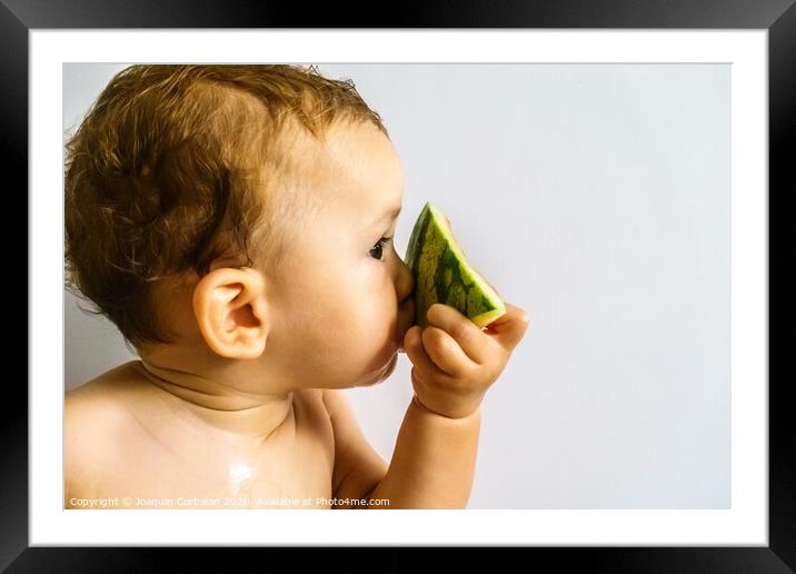Baby in profile eating a watermelon drooling and getting dirty with the sticky juice of the fruit. Framed Mounted Print by Joaquin Corbalan