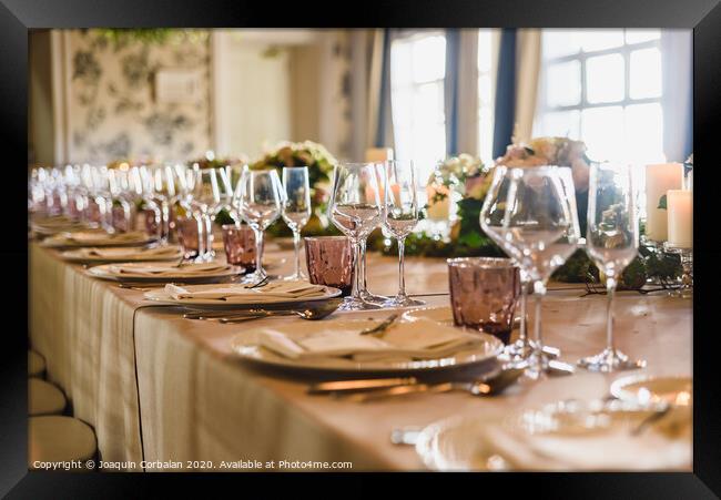 Elongated table with all the cutlery elegantly arranged and beautiful centerpieces ideal for decorating a wedding. Framed Print by Joaquin Corbalan