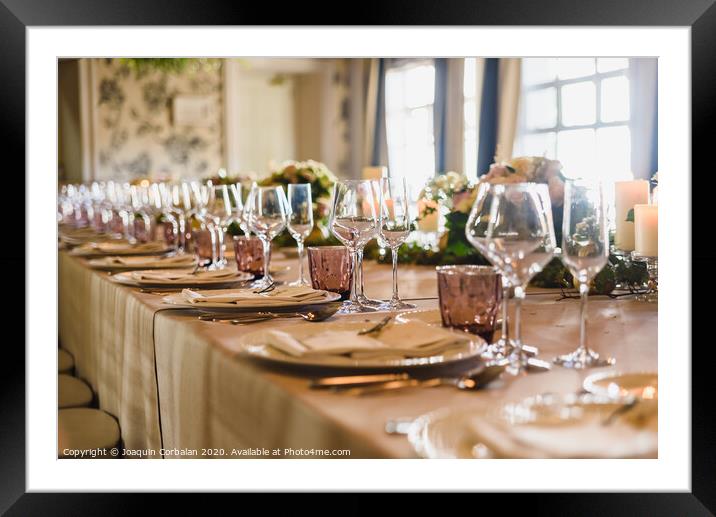 Elongated table with all the cutlery elegantly arranged and beautiful centerpieces ideal for decorating a wedding. Framed Mounted Print by Joaquin Corbalan