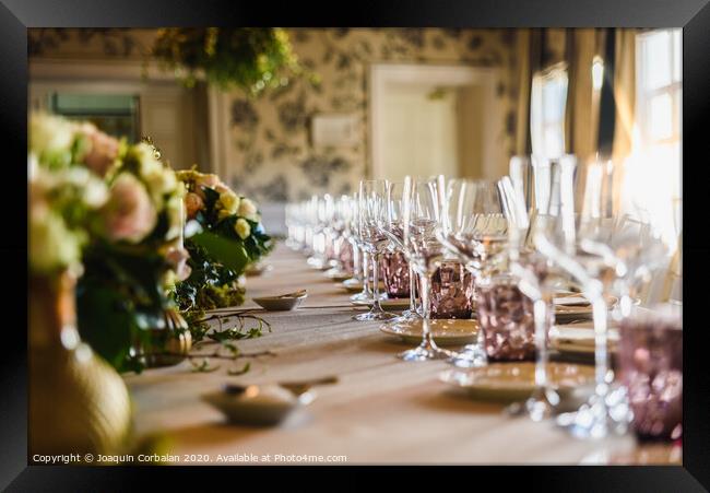 Elongated table with all the cutlery elegantly arranged and beautiful centerpieces ideal for decorating a wedding. Framed Print by Joaquin Corbalan