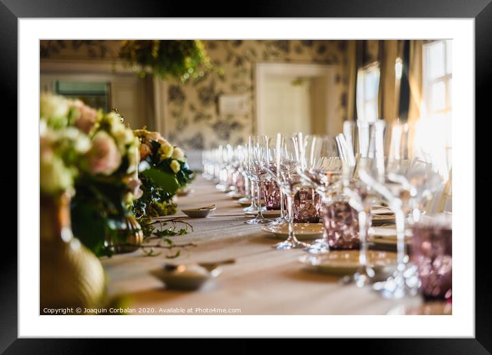 Elongated table with all the cutlery elegantly arranged and beautiful centerpieces ideal for decorating a wedding. Framed Mounted Print by Joaquin Corbalan